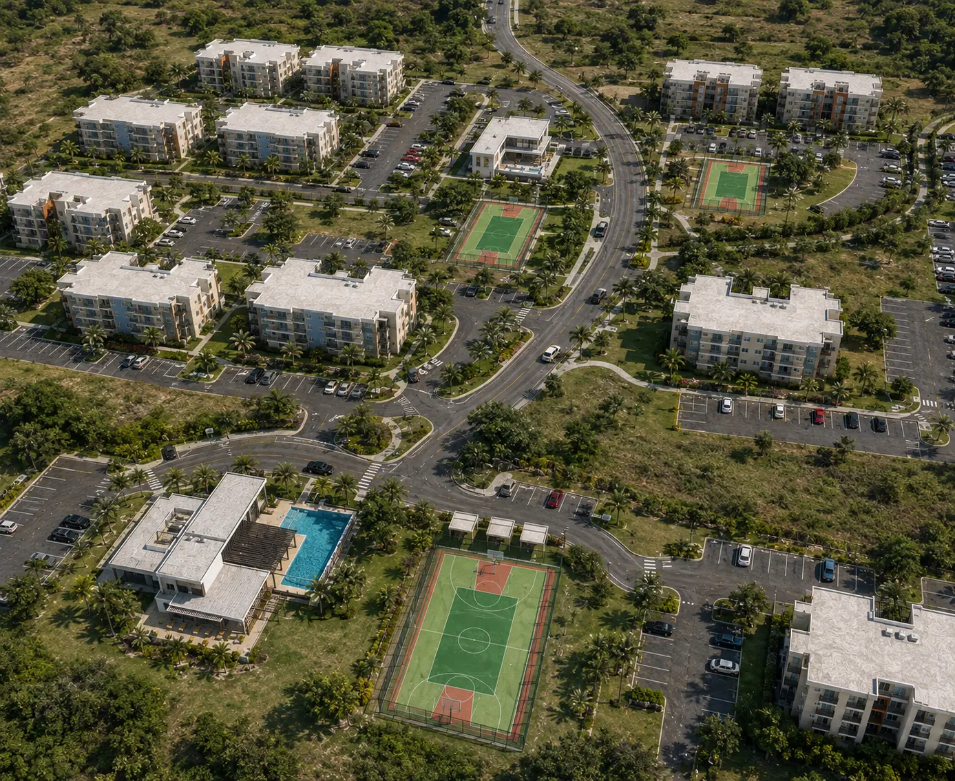 Aerial view of the Prime Cove residential community with apartments, pool house, sports courts, and landscaped grounds